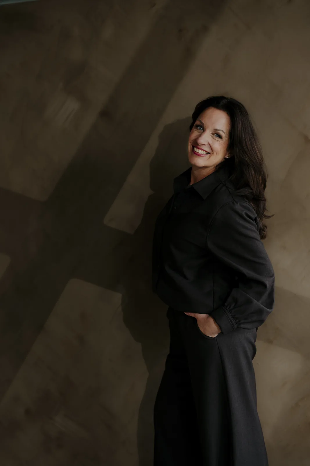 Ivanka Schregardus, oprichter van Behind Patterns, lachend tegen een getextureerde wand